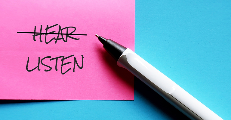 ActiveListen_2 • Roche Leadership Sticky note with “HEAR” crossed out and “LISTEN” written beneath, emphasizing the importance of intentional listening.