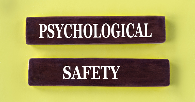 TeamPerform_2 • Roche Leadership Two dark brown blocks with the words "Psychological" and "Safety" in bold white letters are placed against a light yellow background.