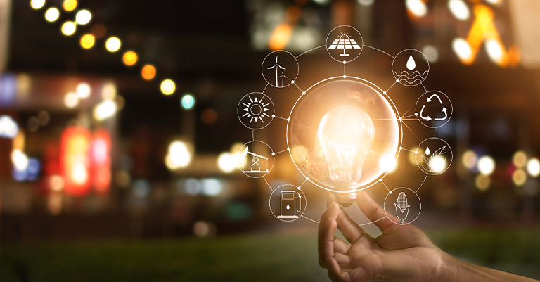 TimeMgmt_6 • Roche Leadership Hand holding glowing lightbulb with icons representing energy and sustainability around it.